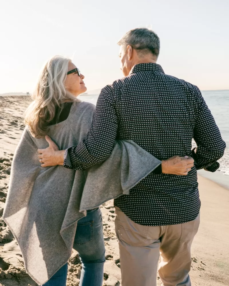 Retired couple walking along the beach
